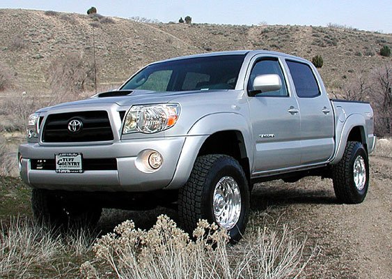 A silver 2008 Toyota Tacoma, which falls within the Toyota Tacoma years of the second generation (2005-2015), featuring a lifted suspension and aftermarket chrome wheels.