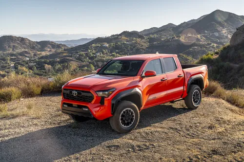 Front three-quarter view of a 2024 Toyota Tacoma, the latest and most modern iteration in the Toyota Tacoma years lineup, showing off its bold new grille and LED headlights.