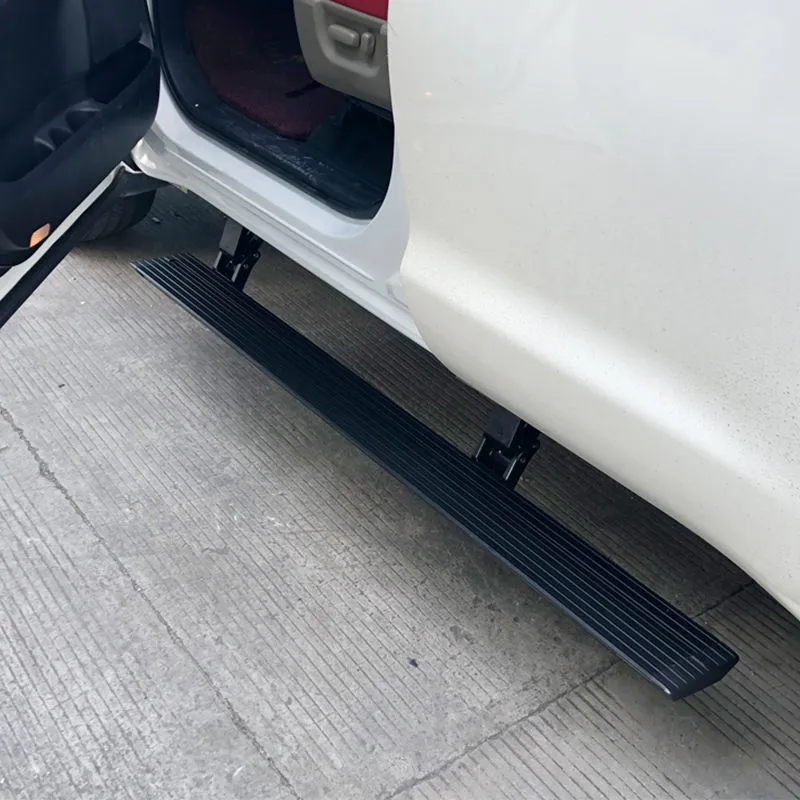 A close-up of the Toyota FJ power running boards lowered into position, with the passenger door open to demonstrate the convenient height for stepping into the white off-road SUV.