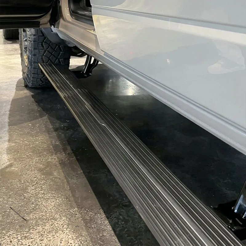 Close-up view of deployed black side steps showcasing ford f150 running boards on a vehicle.