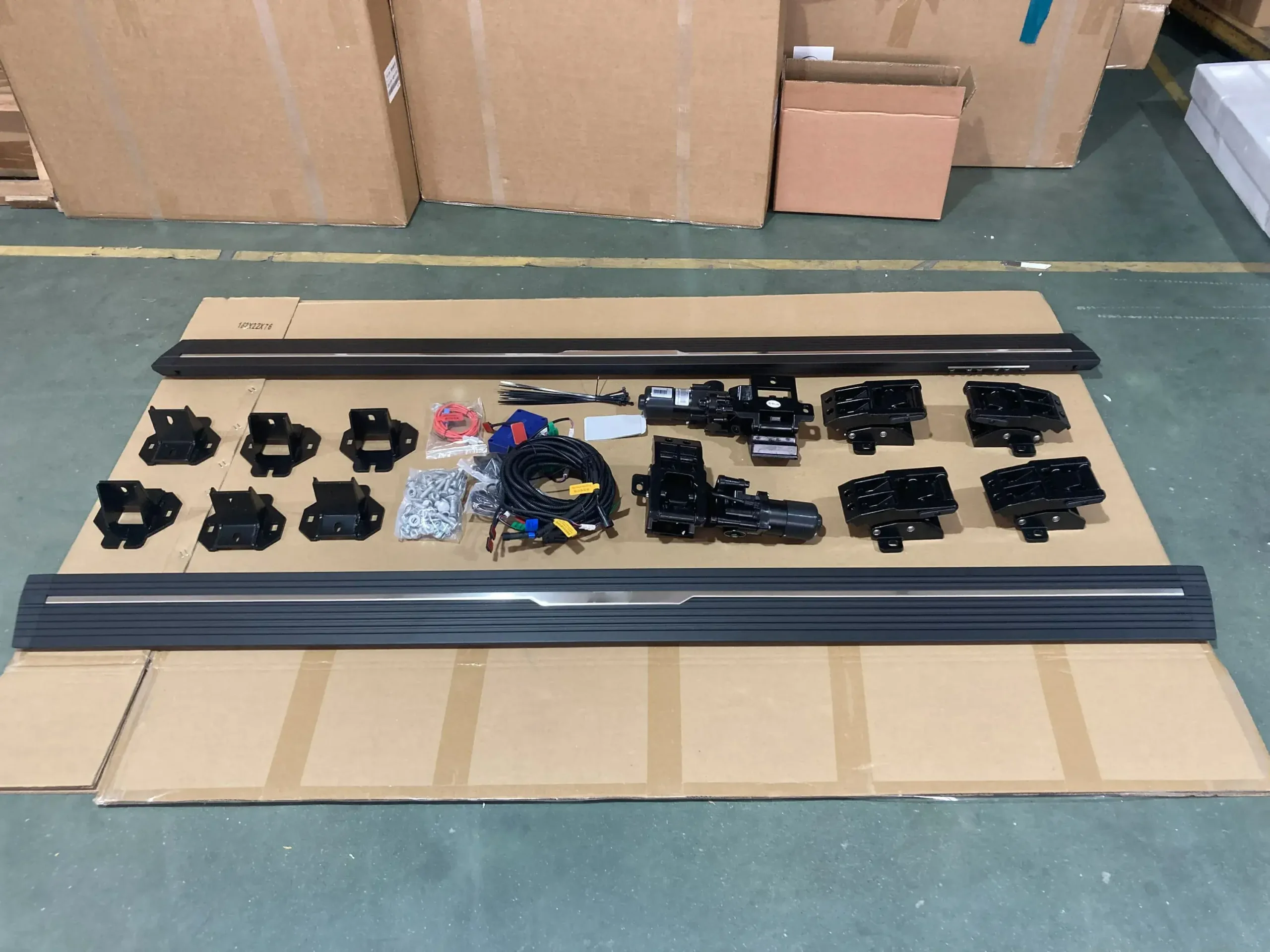 Complete set of gmc canyon running boards components laid out on a factory floor for quality inspection.