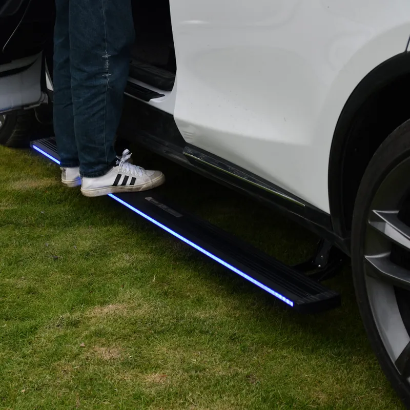 A person stepping onto deployed gmc sierra 1500 running boards featuring bright LED accent lights.