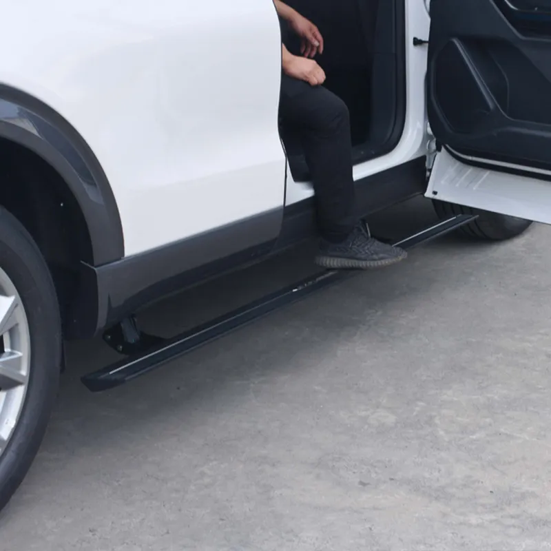 A person stepping onto deployed electronic gmc sierra running boards from a white vehicle.