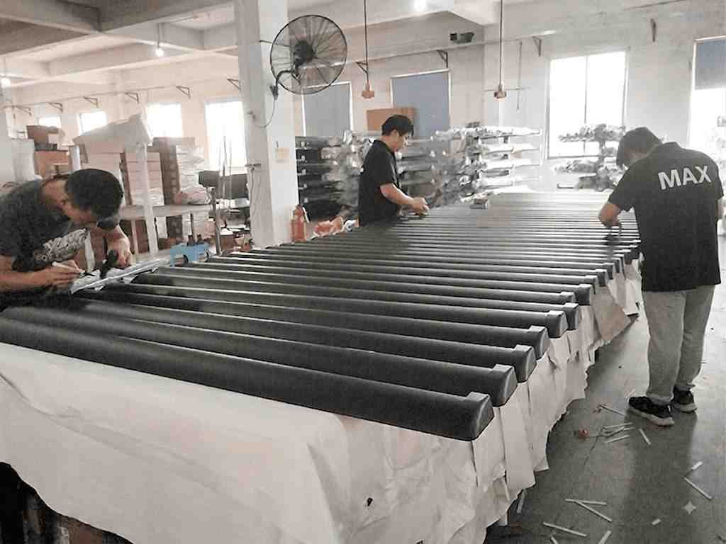 Workers inspecting and assembling power running boards in factory mass production line