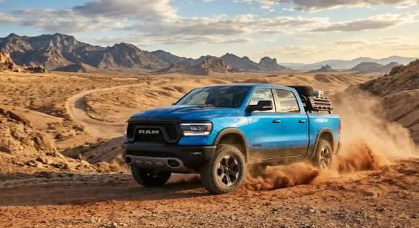 A blue Ram 1500 truck driving through the desert, kicking up dust, showcasing its rugged ram 1500 towing capacity.