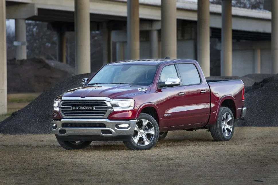A maroon Ram 1500 pickup truck parked near gravel mounds and a concrete bridge, highlighting its powerful ram 1500 towing capacity.