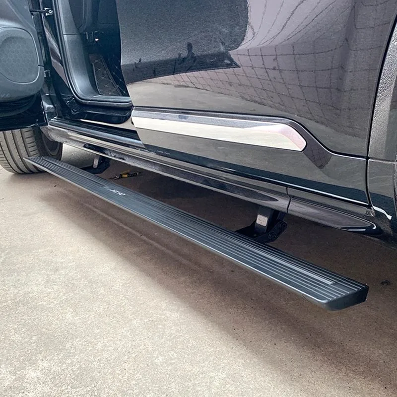 Deployed Chevrolet Blazer power running boards installed on a black SUV, showing the sturdy aluminum step and mounting brackets beneath the open door.