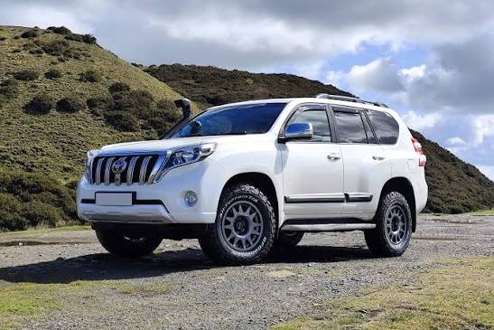 White Toyota Land Cruiser 150 Series (LC150) Prado parked in an off-road landscape, representing a Power Running Boards Manufacturer.