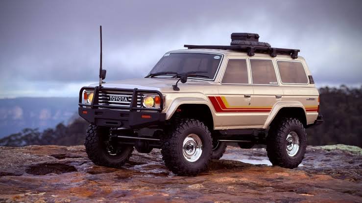 Beige Toyota Land Cruiser 60 Series (LC60) parked on rocks, representing a Power Running Boards Manufacturer.