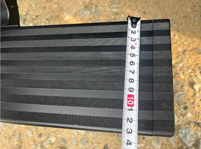 Close-up of the anti-slip surface dimensions for custom Electric running boards measured with a tape.