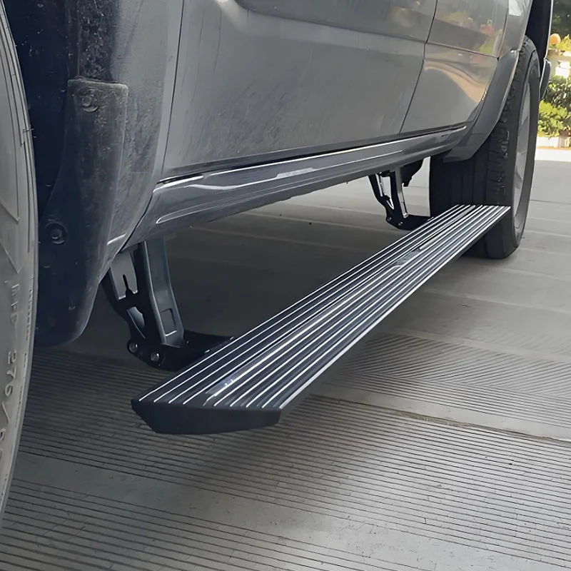 Close-up of deployed BYD Ti 7 Electric Side Steps on a grey SUV, highlighting the anti-slip textured running board, heavy-duty hinge mechanism, and undercarriage clearance.