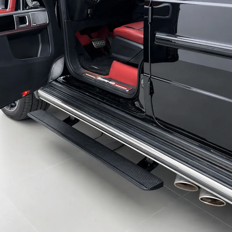 Detailed view of the fully deployed Mercedes-Benz G500 Electric Running Boards on a black G-Class, highlighting the step access next to the open door and side exhaust.