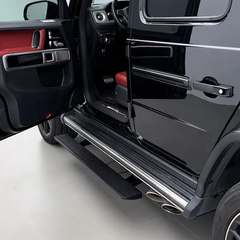 Open door view of a black Mercedes-Benz G500 revealing the extended Mercedes-Benz G500 Electric Running Boards and the vehicle's red and black interior door panels.