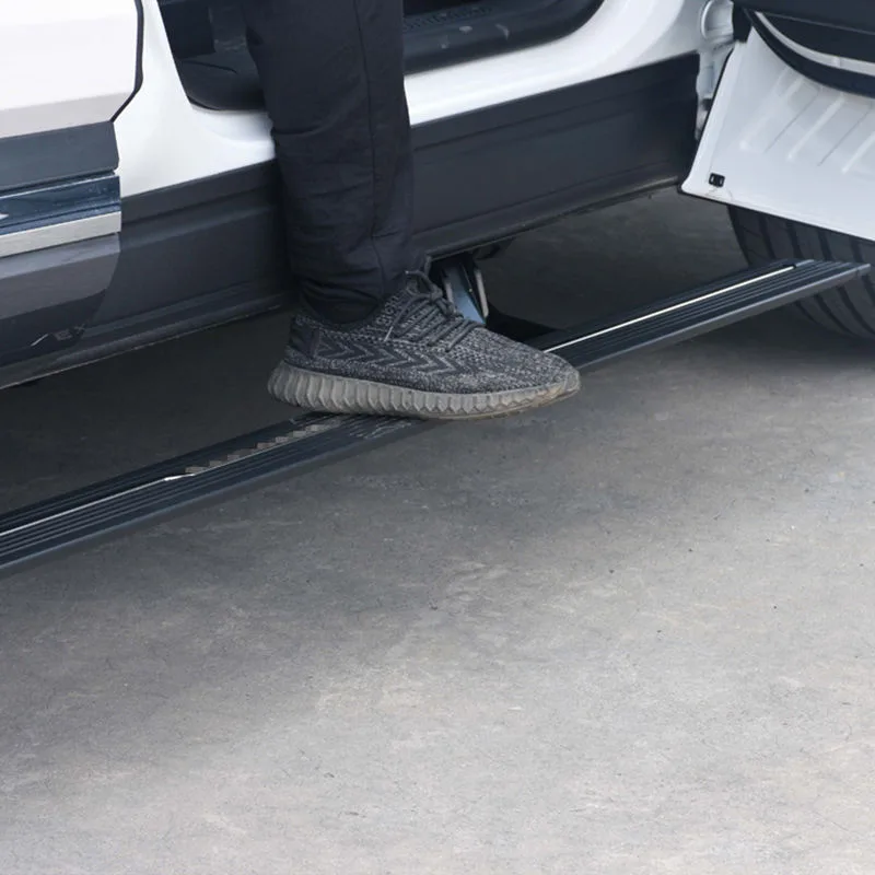 Range Rover Velar Electric Side Steps supporting a person stepping onto the deployed running board of a white SUV.