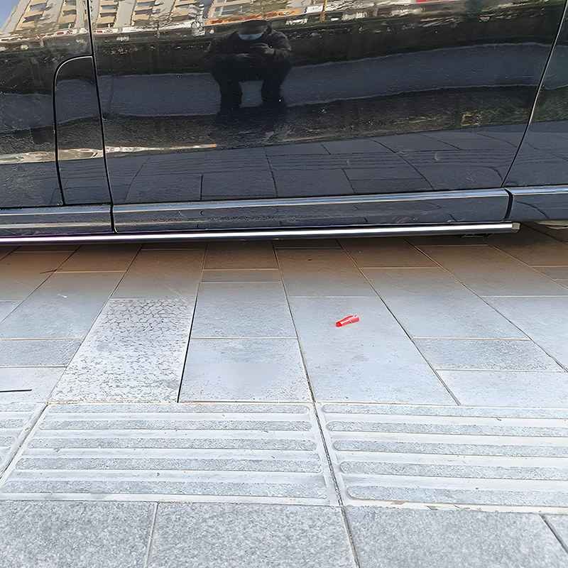 Low angle view of a black vehicle showing the Mercedes-Benz V-Class Electric Running Boards neatly retracted under the chassis, flush with the body line.