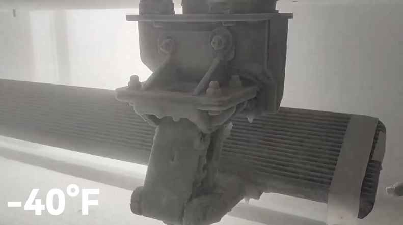 Close-up of an ice-covered electric running boards mechanism during a -40°F cold test.