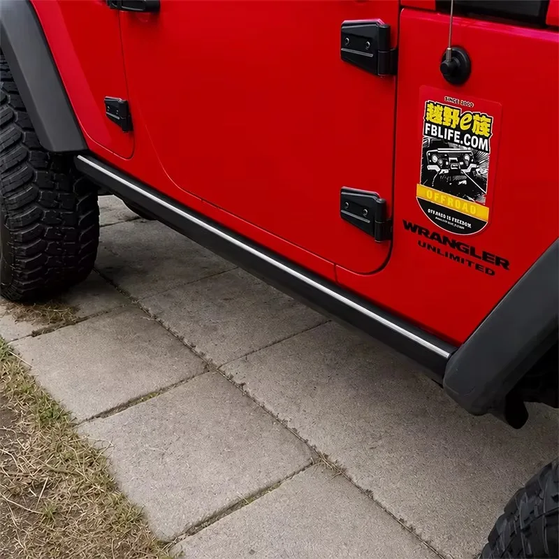 Jeep Wrangler power running boards with a white LED strip illuminated under the doors, mounted on a red Wrangler Unlimited.