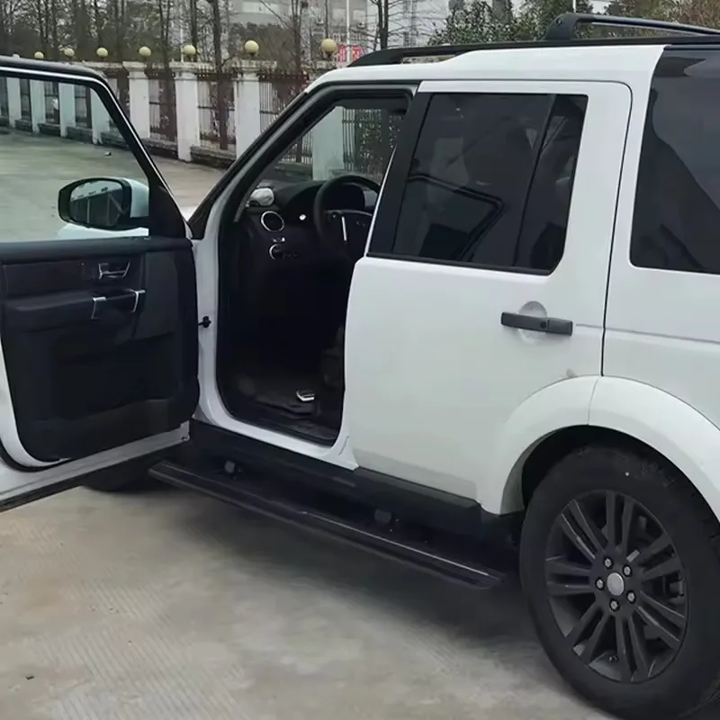 Open front door of a white Land Rover Discovery 3 Electric Side Steps deployed outdoors, showing the interior and step access.