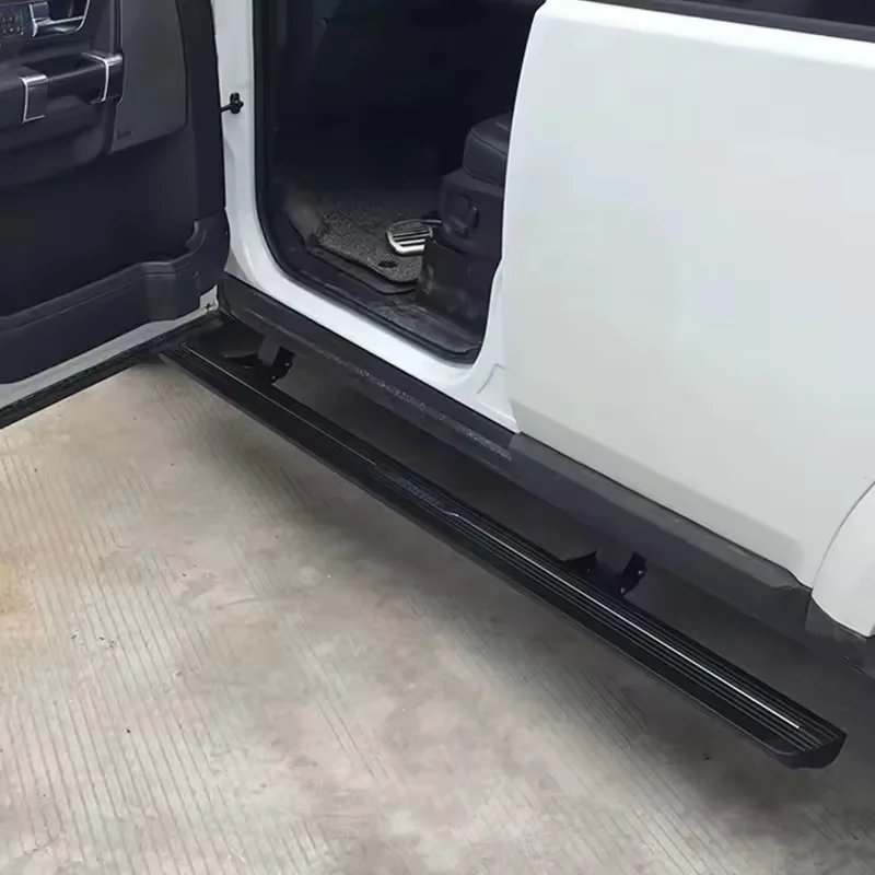 Close-up of the deployed Land Rover Discovery 3 Electric Side Steps running board with textured black tread, seen through an open car door.