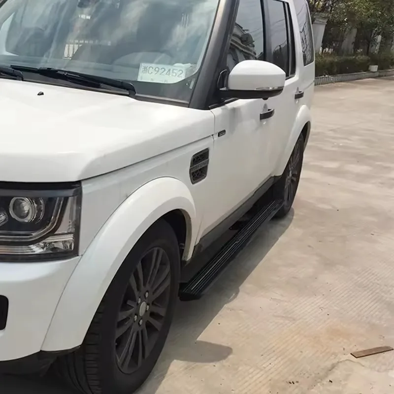 White Land Rover Discovery 4 Electric Side Steps in the retracted position, parked outdoors on a concrete surface.