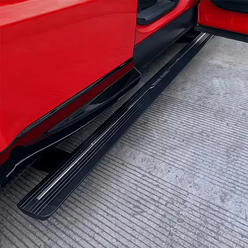Close-up of an open door on a red Range Rover Sport, highlighting the deployed Range Rover Sport Electric Side Steps on a textured concrete surface.
