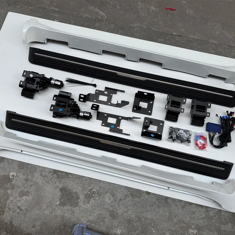 Unassembled lexus gx460 electric running boards kit laid out on a concrete floor, showing step bars, mounting brackets, motors, and hardware.