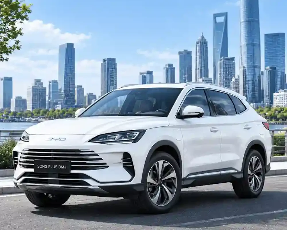White BYD Song PLUS DM-i SUV fitted with byd electric side steps, parked on a paved road against a high-rise cityscape.